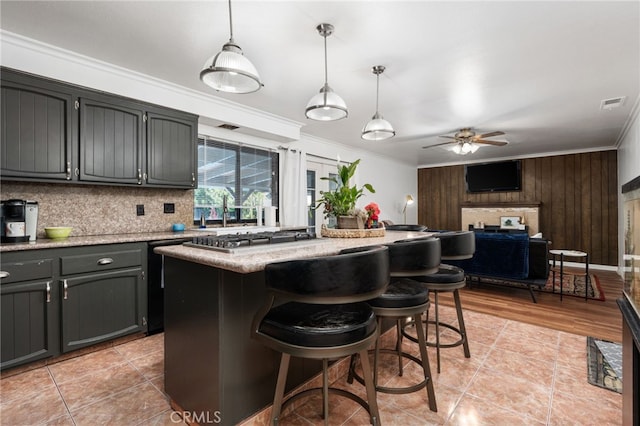 3367 M St, Merced, CA 95348 - kitchen with crown molding, ceiling fan, stainless steel gas cooktop, tasteful backsplash, and a kitchen island