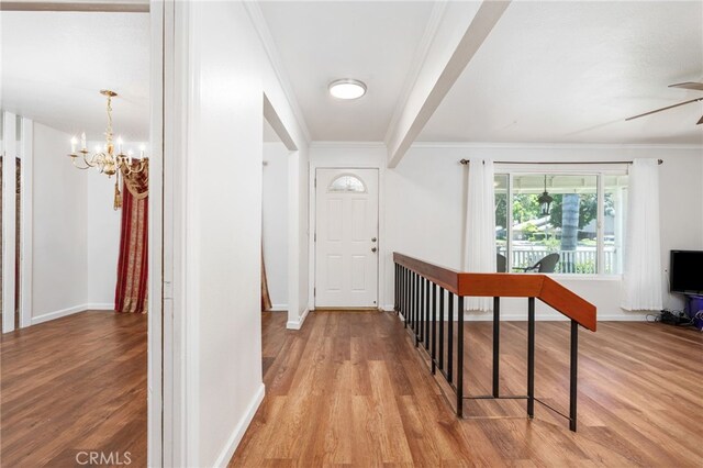 3367 M St, Merced, CA 95348 - hall with wood finished floors, a chandelier, crown molding, and an upstairs landing