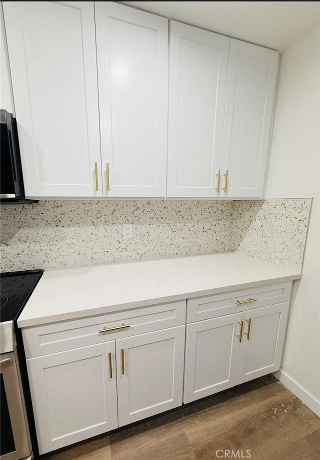 4170 Elm Ave Unit 213, Long Beach, CA 90807 - detailed view of range with electric cooktop, wood finished floors, white cabinetry, and light countertops