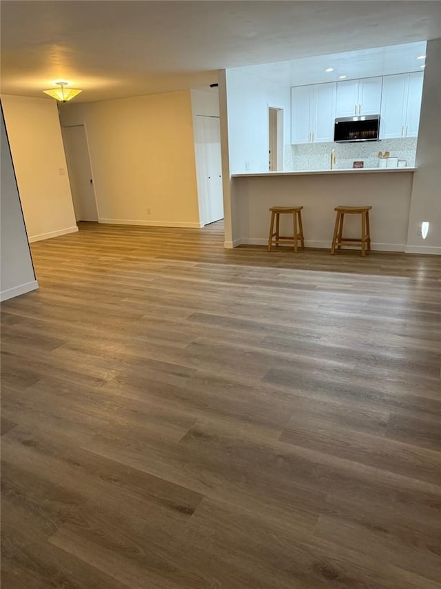 4170 Elm Ave Unit 213, Long Beach, CA 90807 - unfurnished living room featuring baseboards and dark wood-type flooring