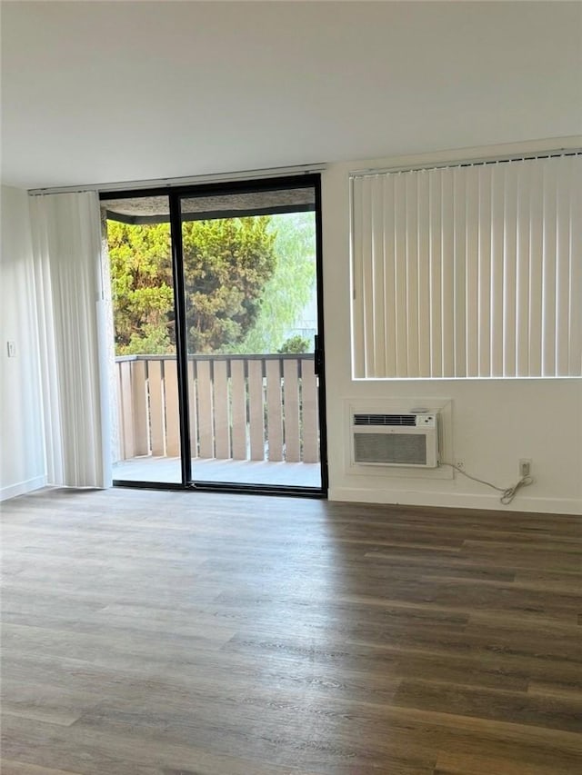 4170 Elm Ave Unit 213, Long Beach, CA 90807 - spare room with healthy amount of natural light, wood finished floors, an AC wall unit, and expansive windows