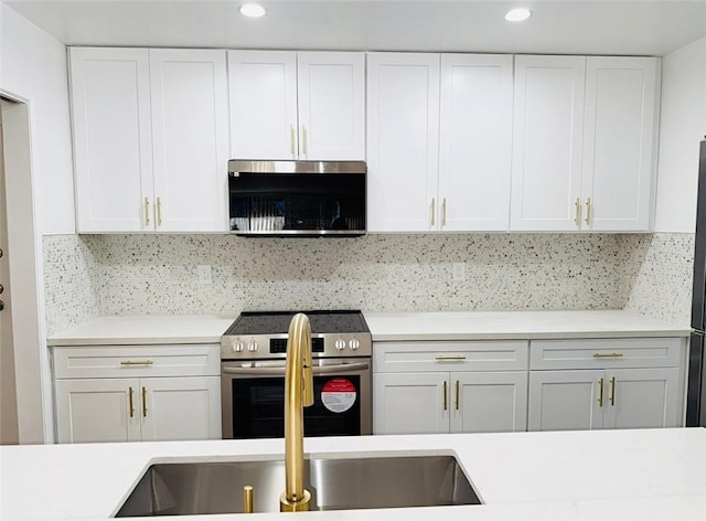 4170 Elm Ave Unit 213, Long Beach, CA 90807 - kitchen featuring appliances with stainless steel finishes, light countertops, decorative backsplash, white cabinets, and recessed lighting