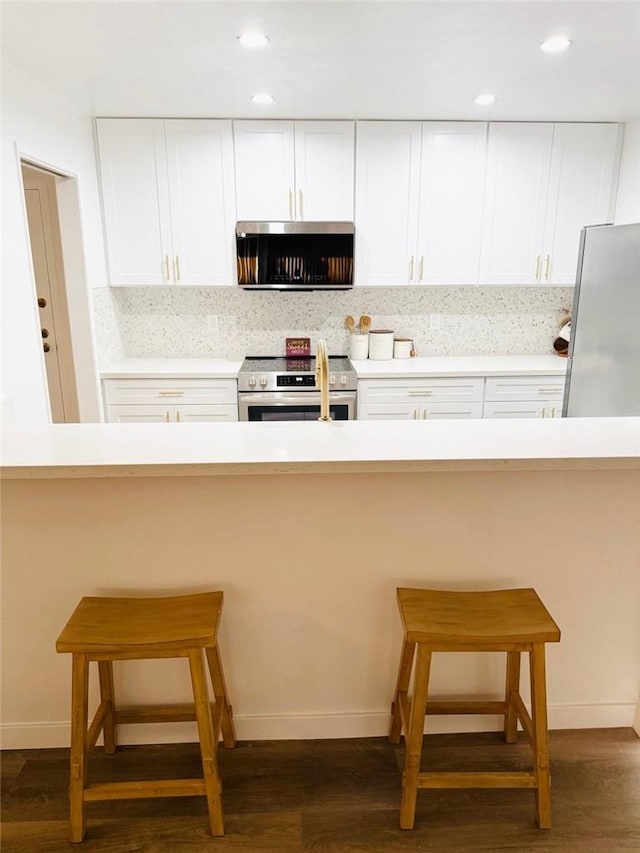 4170 Elm Ave Unit 213, Long Beach, CA 90807 - kitchen featuring appliances with stainless steel finishes, backsplash, dark wood-style floors, white cabinetry, and recessed lighting