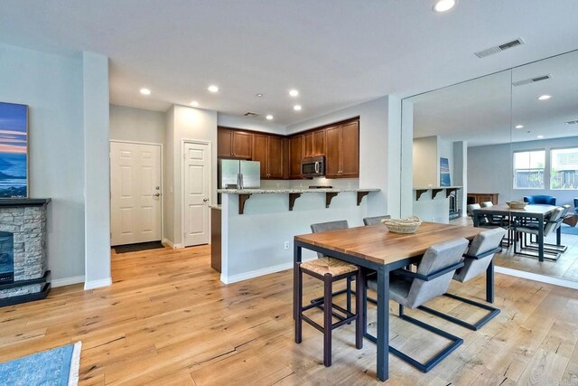6925 Tourmaline, Carlsbad, CA 92009 - dining space with light wood-type flooring, recessed lighting, and a fireplace