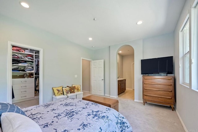 6925 Tourmaline, Carlsbad, CA 92009 - bedroom with arched walkways, a walk in closet, light carpet, recessed lighting, and a closet