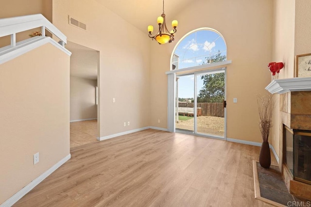 1499 Bay Meadows Dr, Alpine, CA 91901 - unfurnished dining area featuring a towering ceiling, a chandelier, wood finished floors, and a tile fireplace