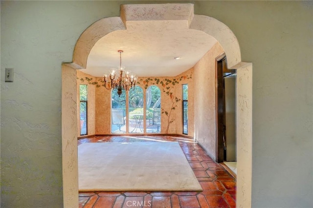 2033 Benbow Pl, Riverside, CA 92506 - unfurnished dining area with a chandelier, a textured wall, and arched walkways