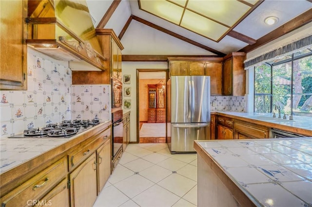 2033 Benbow Pl, Riverside, CA 92506 - kitchen featuring stainless steel appliances, vaulted ceiling, tile countertops, tasteful backsplash, and custom range hood