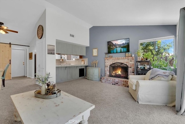 801 Vine St, Exeter, CA 93221 - carpeted living area featuring a barn door, a fireplace, and high vaulted ceiling