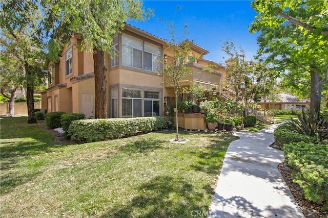 19431 Rue De Valore Unit 5C, Lake Forest, CA 92610 - view of front of property with stucco siding, a front lawn, and a tile roof