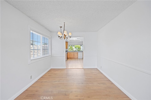 1736 Park Lawn Rd, Hacienda Heights, CA 91745 - empty room with a chandelier, light wood-style flooring, and a textured ceiling