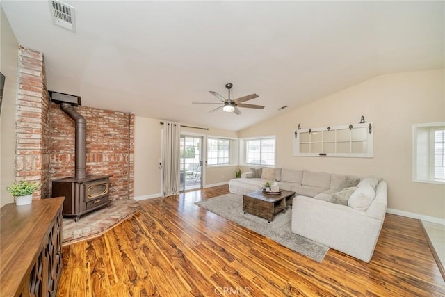 18210 Deauville Dr, Victorville, CA 92395 - living area with wood finished floors, ceiling fan, vaulted ceiling, and a wood stove