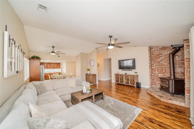 18210 Deauville Dr, Victorville, CA 92395 - living area with a ceiling fan, lofted ceiling, light wood-style floors, and a wood stove