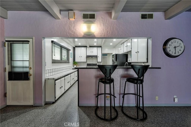 2120 N Rose St, Burbank, CA 91505 - kitchen with beamed ceiling, freestanding refrigerator, a peninsula, white cabinets, and a breakfast bar