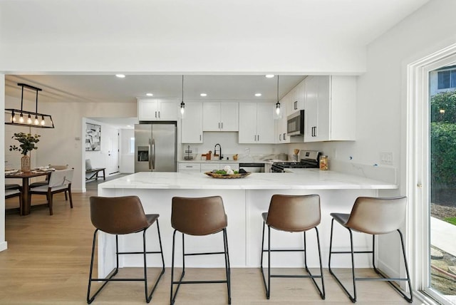 305 Spruce St, Chula Vista, CA 91911 - kitchen featuring stainless steel appliances, a peninsula, light wood finished floors, white cabinets, and recessed lighting