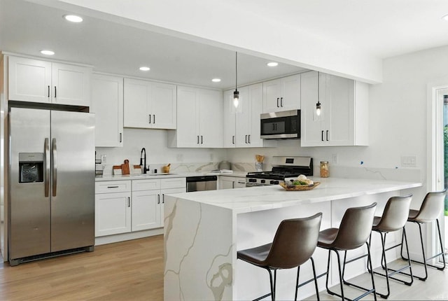 305 Spruce St, Chula Vista, CA 91911 - kitchen with stainless steel appliances, a peninsula, white cabinetry, light wood-type flooring, and recessed lighting