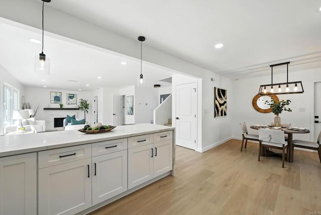 305 Spruce St, Chula Vista, CA 91911 - kitchen featuring light wood-style floors, light countertops, recessed lighting, white cabinetry, and decorative light fixtures