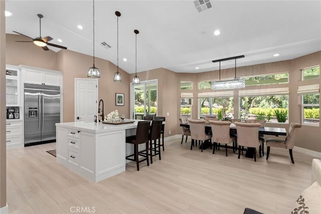 16261 Pineview Rd, Canyon Country, CA 91387 - kitchen with built in fridge, a kitchen breakfast bar, a ceiling fan, white cabinetry, and light countertops