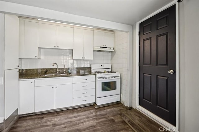 7803 Clive Ave, Whittier, CA 90606 - kitchen with white gas range, under cabinet range hood, dark stone counters, dark wood-style flooring, and white cabinetry