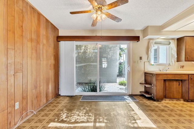 4760 73rd St, La Mesa, CA 91942 - doorway featuring a textured ceiling, wooden walls, and a ceiling fan