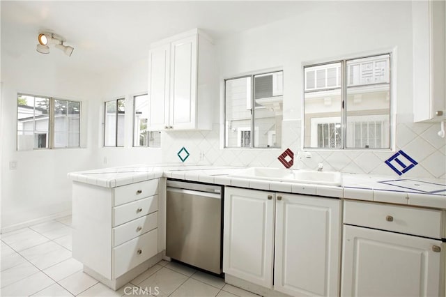 738 S Norton Ave, Los Angeles, CA 90005 - kitchen featuring stainless steel dishwasher, white cabinetry, tasteful backsplash, and tile countertops