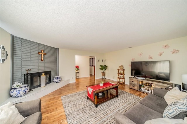 12995 Leith Way, Yucaipa, CA 92399 - living room with a textured ceiling, wood finished floors, and a tiled fireplace
