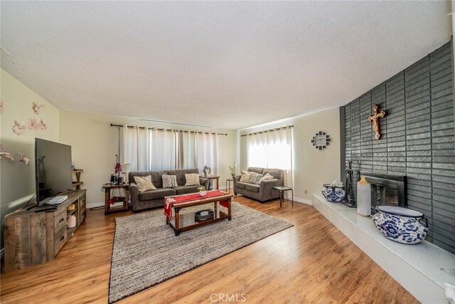 12995 Leith Way, Yucaipa, CA 92399 - living area featuring a tiled fireplace, light wood-style floors, and a textured ceiling