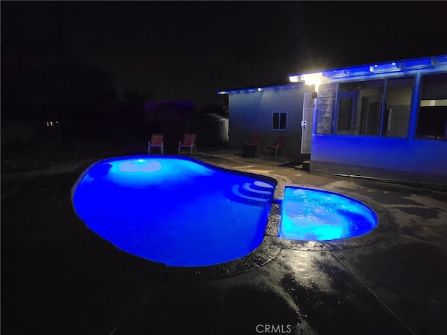 12995 Leith Way, Yucaipa, CA 92399 - pool at night featuring a pool with connected hot tub and a patio area