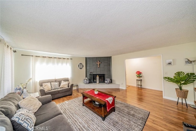 12995 Leith Way, Yucaipa, CA 92399 - living area with a textured ceiling, light wood-style flooring, and a brick fireplace
