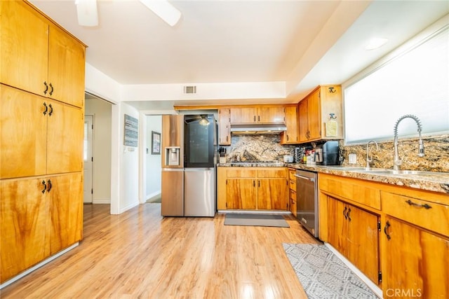 12995 Leith Way, Yucaipa, CA 92399 - kitchen with appliances with stainless steel finishes, ceiling fan, under cabinet range hood, light wood-style floors, and decorative backsplash