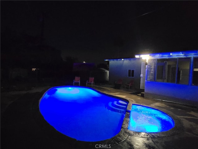 12995 Leith Way, Yucaipa, CA 92399 - pool at night featuring a pool with connected hot tub and a patio area