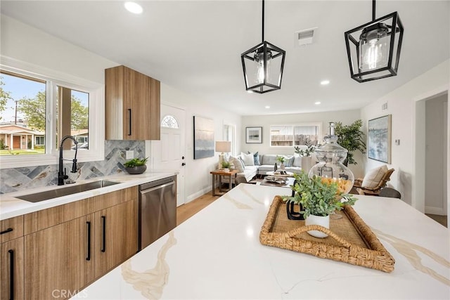 19331 Cindy Ln, Huntington Beach, CA 92646 - kitchen with dishwasher, open floor plan, brown cabinetry, recessed lighting, and light stone counters