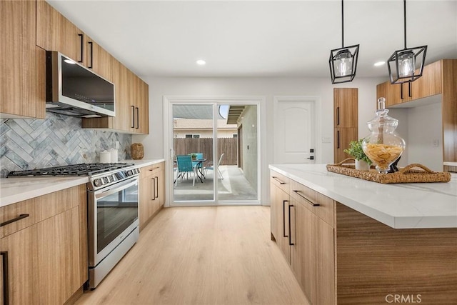 19331 Cindy Ln, Huntington Beach, CA 92646 - kitchen with appliances with stainless steel finishes, modern cabinets, light wood-type flooring, tasteful backsplash, and decorative light fixtures