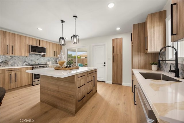 19331 Cindy Ln, Huntington Beach, CA 92646 - kitchen featuring appliances with stainless steel finishes, modern cabinets, tasteful backsplash, brown cabinets, and recessed lighting