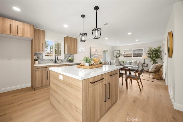 19331 Cindy Ln, Huntington Beach, CA 92646 - kitchen with modern cabinets, a center island, light wood-style flooring, light countertops, and recessed lighting