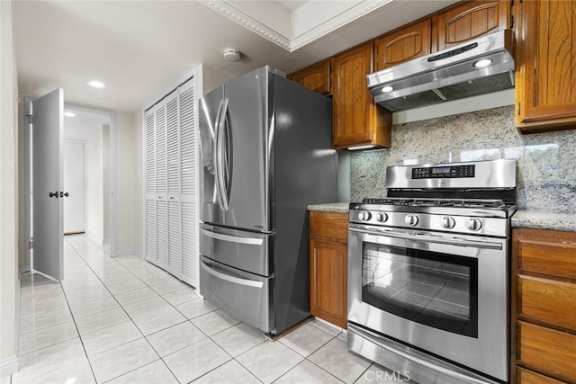 635 E Elmwood Ave Unit 307, Burbank, CA 91501 - kitchen featuring stainless steel appliances, under cabinet range hood, brown cabinets, light tile patterned floors, and backsplash