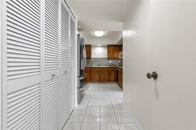 635 E Elmwood Ave Unit 307, Burbank, CA 91501 - kitchen with brown cabinets, freestanding refrigerator, light tile patterned flooring, decorative backsplash, and a raised ceiling