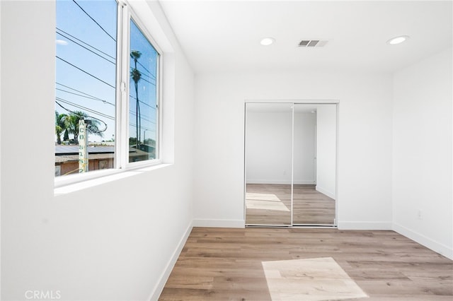 10415 Avalon Blvd, Los Angeles, CA 90003 - unfurnished bedroom featuring multiple windows, a closet, light wood-style flooring, and recessed lighting