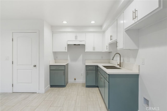 10415 Avalon Blvd, Los Angeles, CA 90003 - kitchen with under cabinet range hood, white cabinetry, recessed lighting, and light countertops