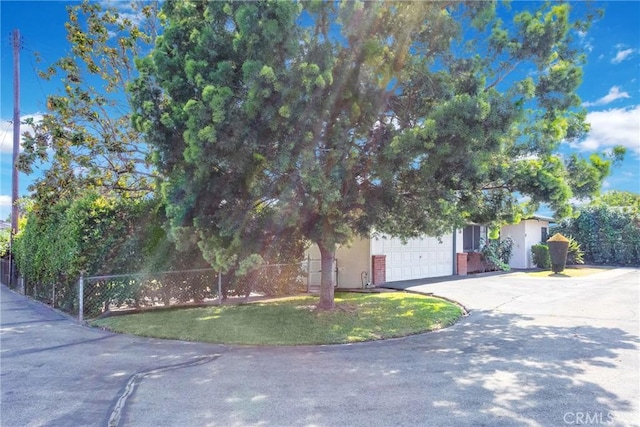4134 Rio Hondo Ave, Rosemead, CA 91770 - view of property hidden behind natural elements with asphalt driveway, an attached garage, stucco siding, and brick siding