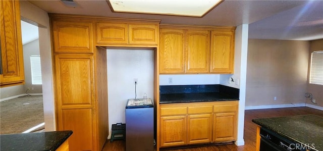 186 S Massachusetts St, Lake Elsinore, CA 92530 - kitchen featuring washer / clothes dryer, dark wood-style flooring, dark stone counters, dishwasher, and brown cabinetry