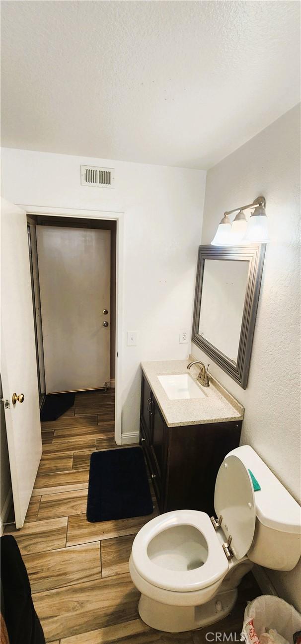 186 S Massachusetts St, Lake Elsinore, CA 92530 - bathroom featuring wood finished floors, vanity, and a textured ceiling