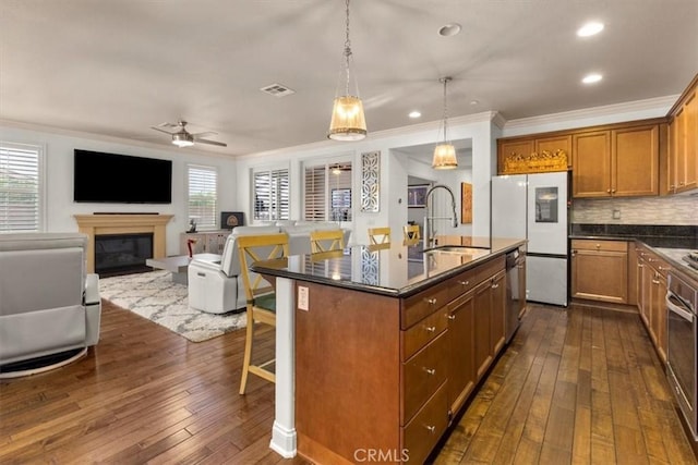 7145 Sunnyside Pl, Rancho Cucamonga, CA 91739 - kitchen featuring freestanding refrigerator, crown molding, dark wood-type flooring, plenty of natural light, and an island with sink