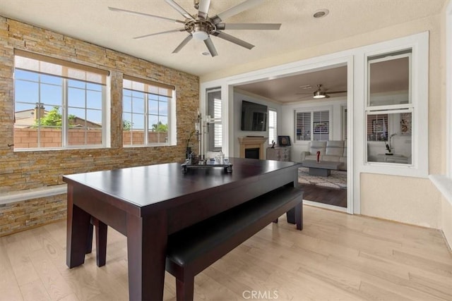 7145 Sunnyside Pl, Rancho Cucamonga, CA 91739 - dining space with a ceiling fan, light wood-type flooring, and a fireplace
