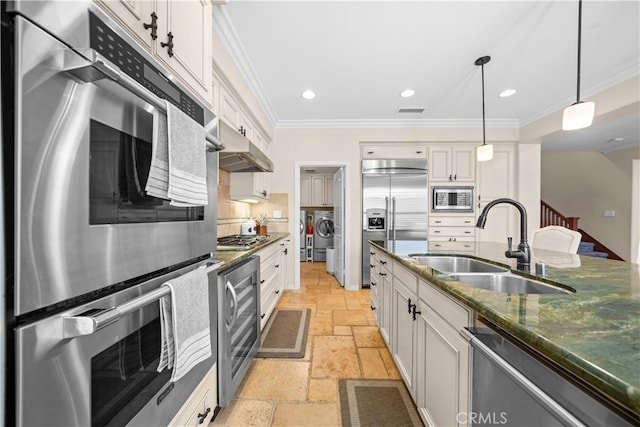 35 Twin Gables, Irvine, CA 92620 - kitchen with built in appliances, stone tile floors, wine cooler, washing machine and dryer, and under cabinet range hood