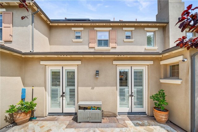 35 Twin Gables, Irvine, CA 92620 - back of property with french doors, a patio area, and stucco siding