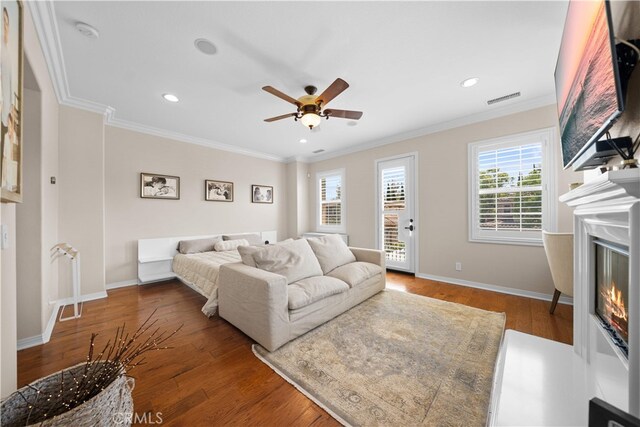 35 Twin Gables, Irvine, CA 92620 - living area featuring crown molding, ceiling fan, a glass covered fireplace, wood finished floors, and recessed lighting