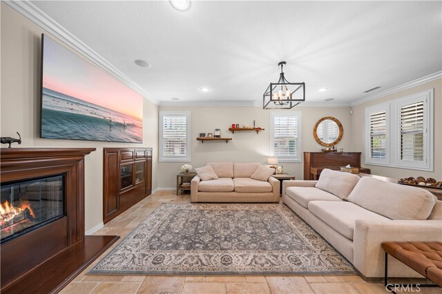 35 Twin Gables, Irvine, CA 92620 - living room featuring ornamental molding, a glass covered fireplace, a chandelier, recessed lighting, and stone tile floors