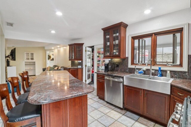 5070 Limerick Ave, Clairemont Mesa, CA 92117 - kitchen featuring dishwasher, a breakfast bar area, backsplash, a kitchen island, and glass insert cabinets