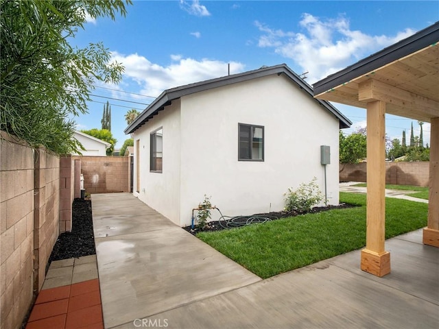 7055 Fallbrook Ave, West Hills, CA 91307 - view of side of home with stucco siding, a fenced backyard, and a patio